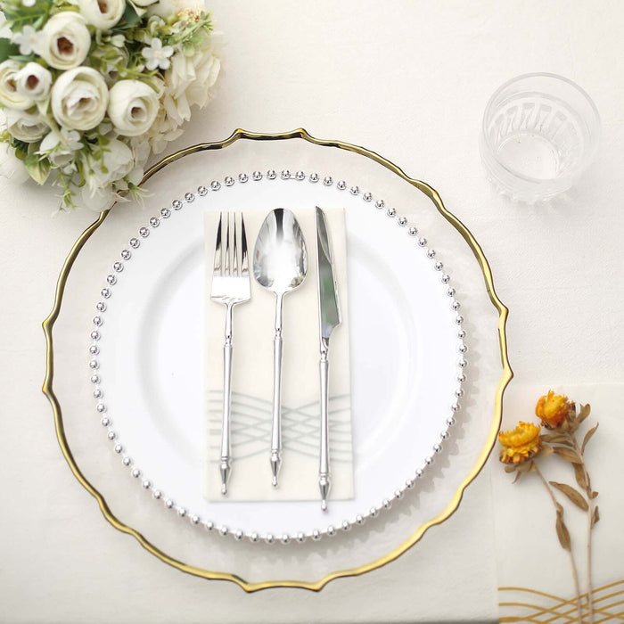 Elegant dining setup with silver cutlery on a decorative plate.