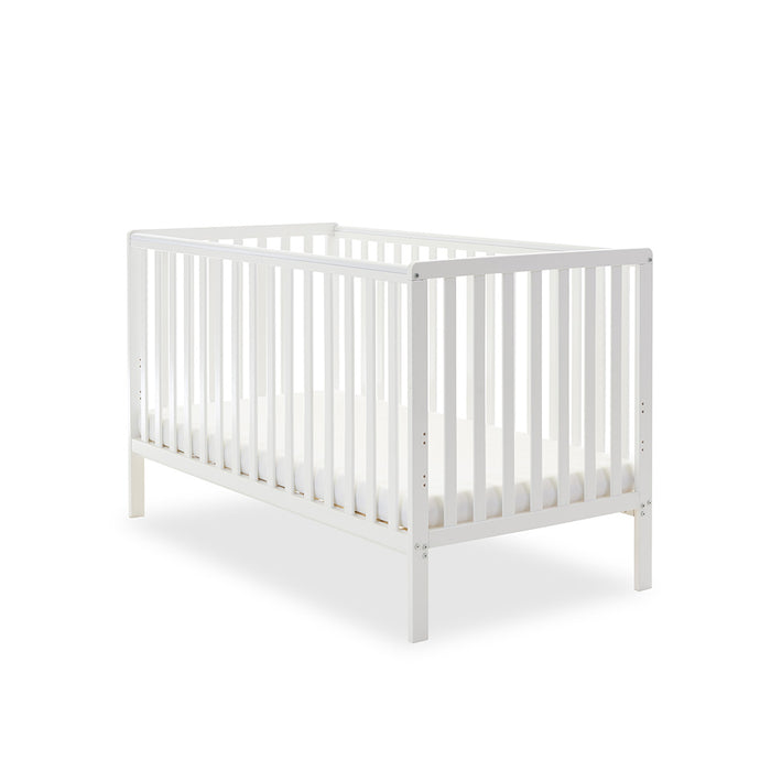 White cot bed with rails on all 4 sides, teething rails on 2 longest sides, base set on the lowest setting.