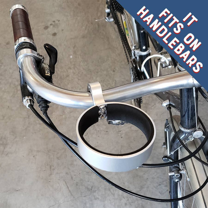 Bicycle handlebar with a cup holder attached, on a concrete floor.