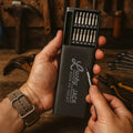 Hand holding a Lucky Jack quick fix toolkit with various bits on a workshop background