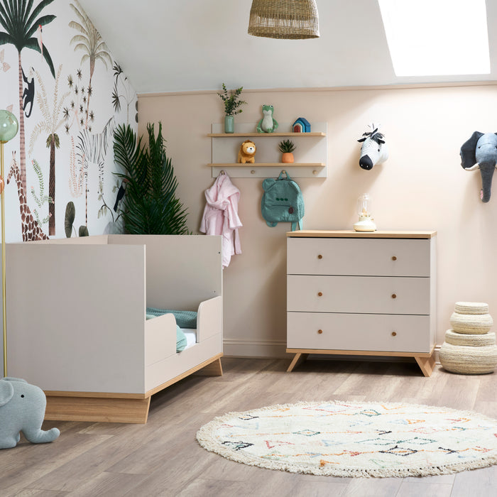 Children's room with crib, dresser, and decorative elements.